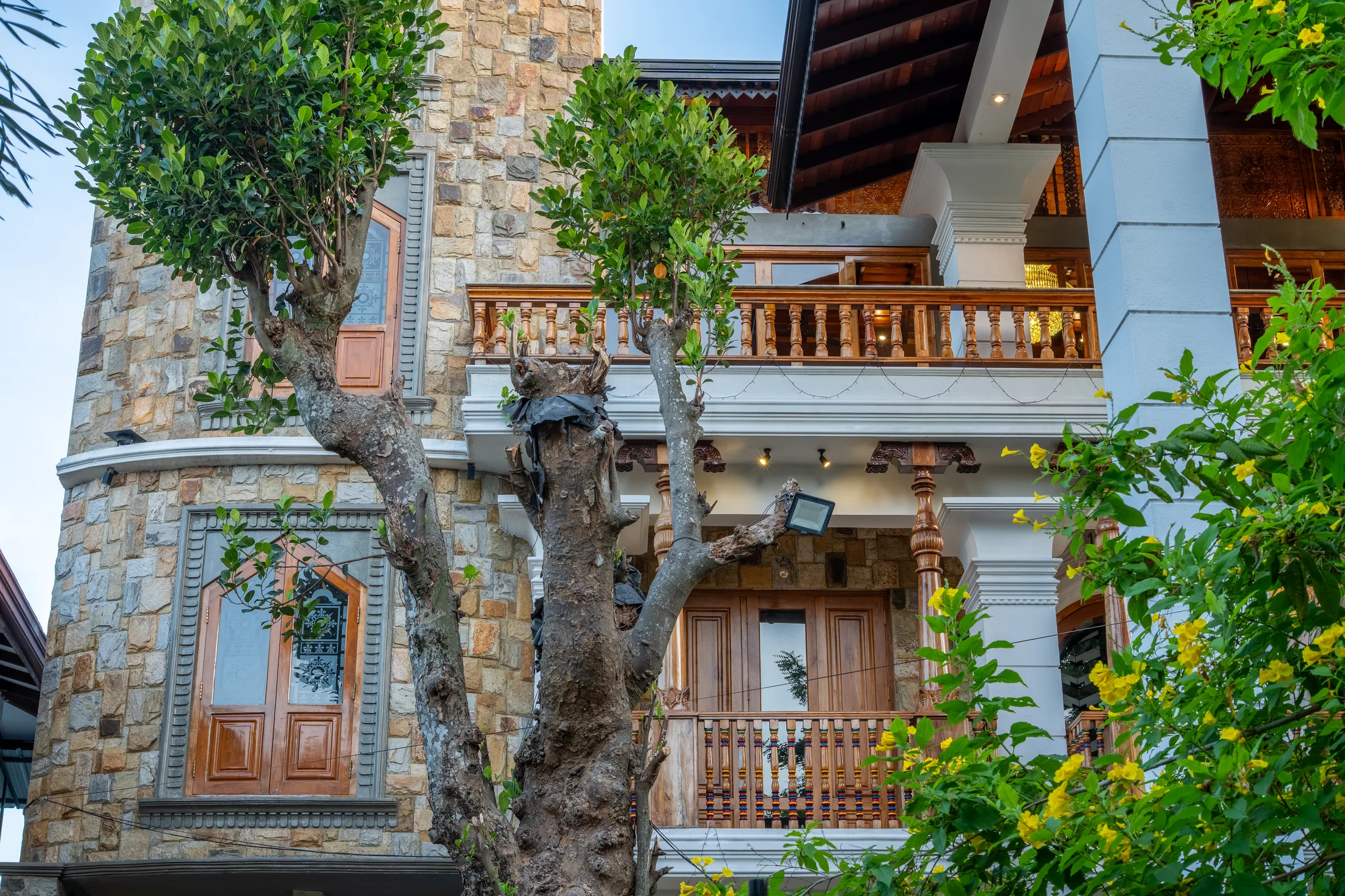 Stone and timber exterior framed by mature trees