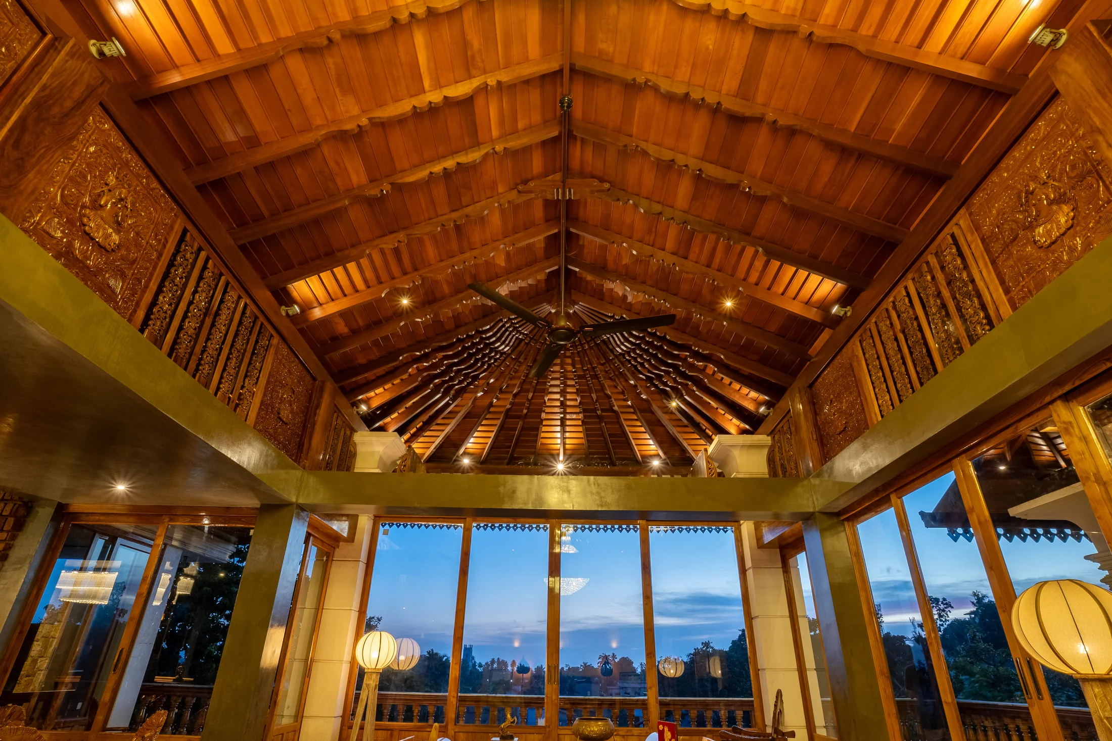 Open-plan living room beneath a dramatic timber ceiling