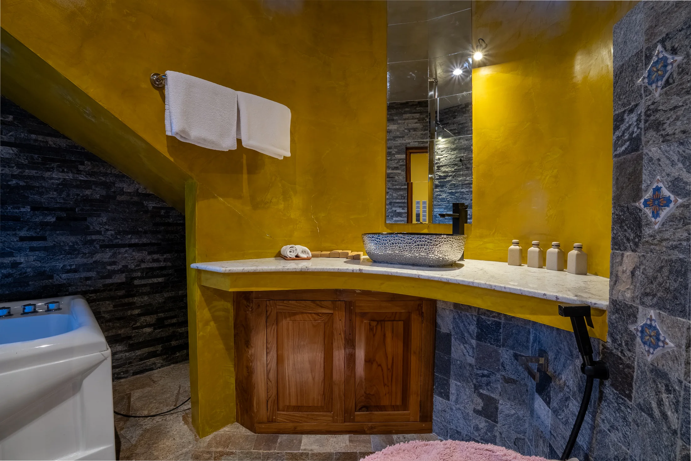 Private en-suite with stone textures and warm golden walls
