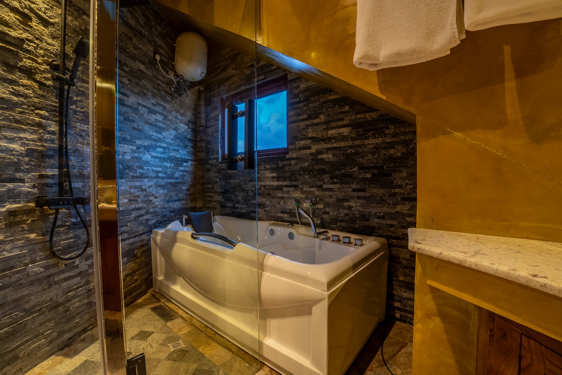 Private en-suite with stone textures and warm golden walls