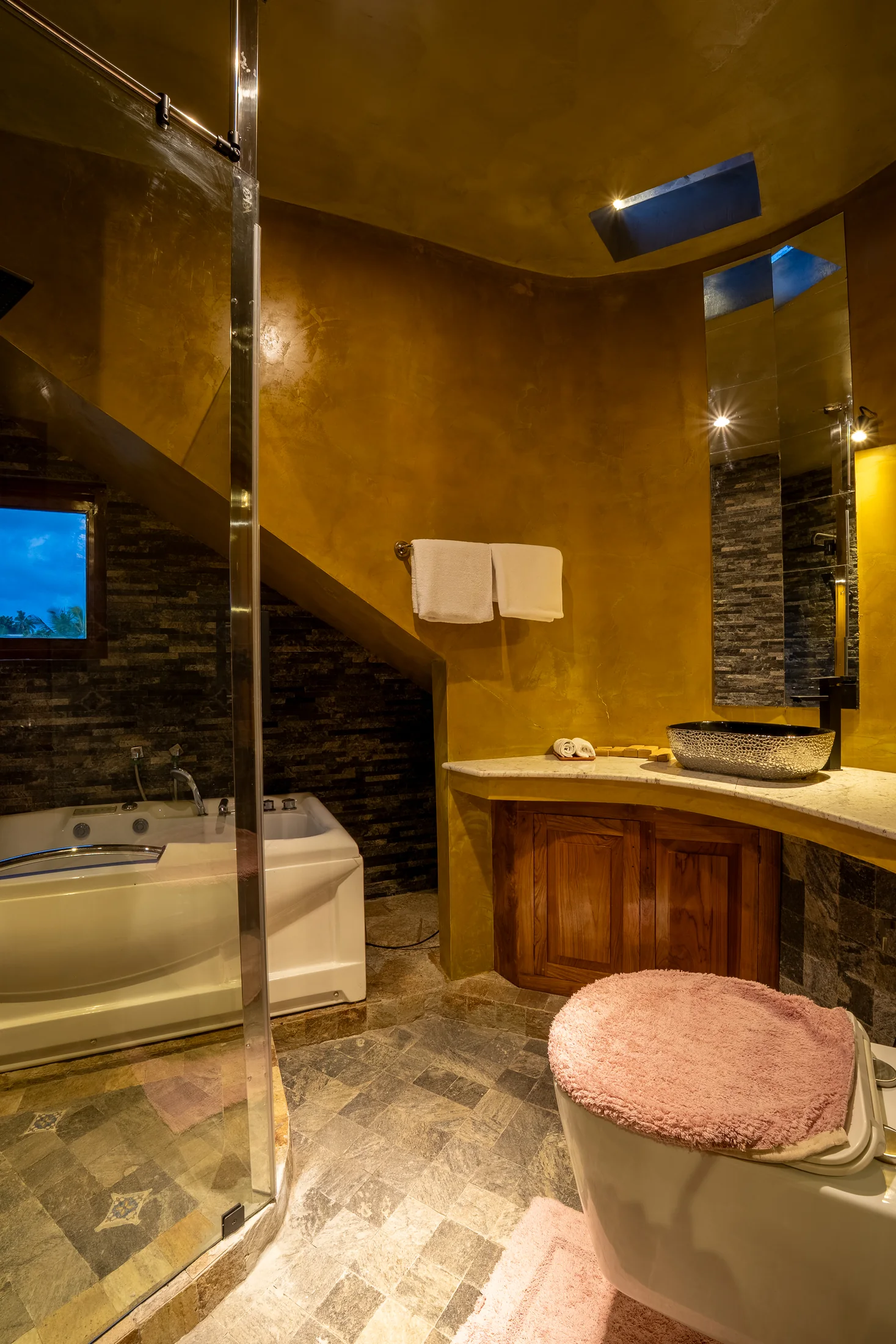 Private en-suite with stone textures and warm golden walls